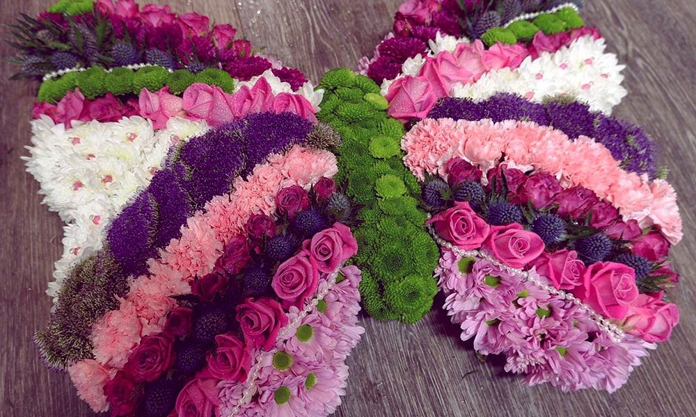 Pink and purple butterfly shaped funeral tribute